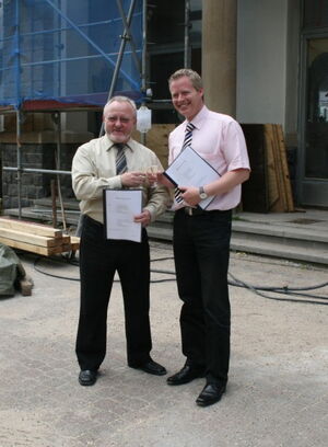 Bürgermeister Siegfried Griebsch (l.) und Ingo Wöste, Geschäftsführer der Woge-Werdohl, stoßen vor dem Bahnhof auf den Mietvertrag an.