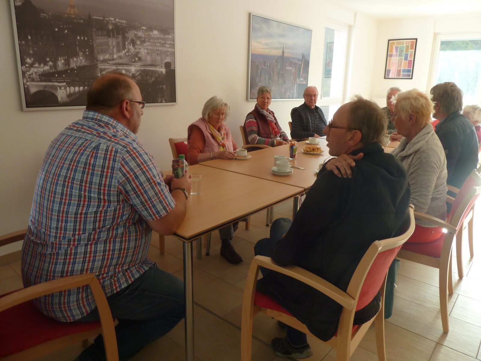 Die betagten Menschen hören Herrn Enser interessiert zu.